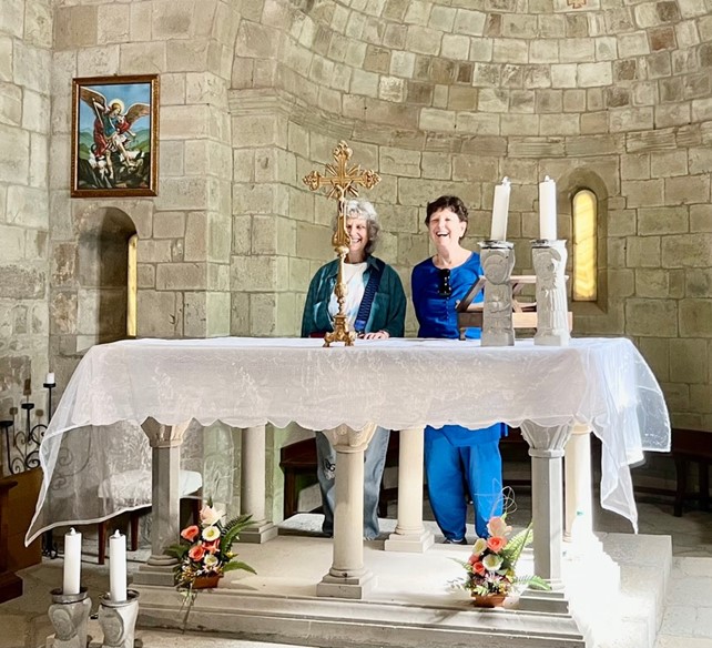Asha and Gitanjali standing behind an altar of a church